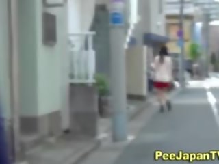 Japanes nuori nainen pissaa ulkopuolella
